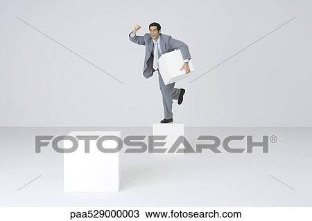 Businessman holding pedestal block, shaking fist View Large Photo Image Stock Image - Businessman holding pedestal block, shaking fist. Fotosearch