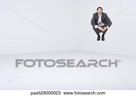 Businessman jumping in midair, shouting at camera View Large Photo Image Stock Image - Businessman jumping in midair, shouting at camera. Fotosearch