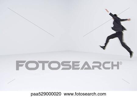 Businessman leaping, blurred motion View Large Photo Image Stock Image - Businessman leaping, blurred motion. Fotosearch