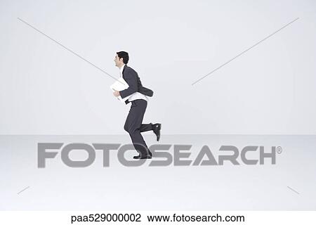 Businessman running with document, blurred motion View Large Photo Image Stock Image - Businessman running with document, blurred motion. Fotosearch