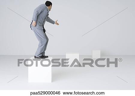 Businessman standing on block, reaching out hand View Large Photo Image Stock Photograph - Businessman standing on block, reaching out hand. Fotosearch
