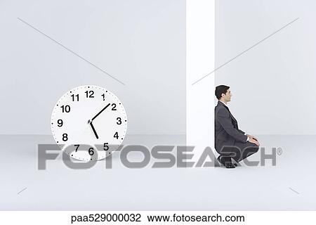 Businessman waiting, near oversized clock View Large Photo Image Stock Image - Businessman waiting, near oversized clock. Fotosearch