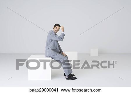 Stock Image - Successful businessman, holding up fist, smiling at camera. Fotosearch