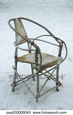 Stock Image - Hand-crafted chair on sand, Zanzibar, Tanzania. Fotosearch