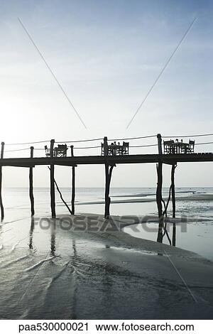 Stock Image - Pier with several dinner tables and chairs, Zanzibar, Tanzania. Fotosearch