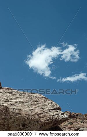 Rocky outcropping, single wispy cloud in sky, low angle view View Large Photo Image Stock Photo - Rocky outcropping, single wispy cloud in sky, low angle view. Fotosearch