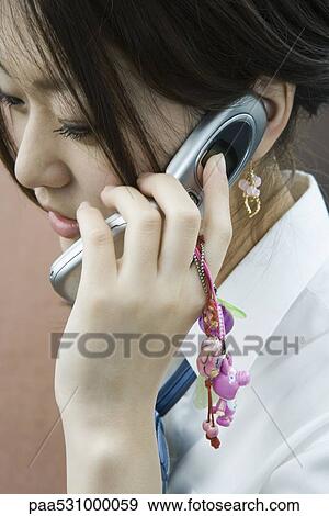 Female using cell phone decorated with charms View Large Photo Image Stock Photo - Female using cell phone decorated with charms. Fotosearch