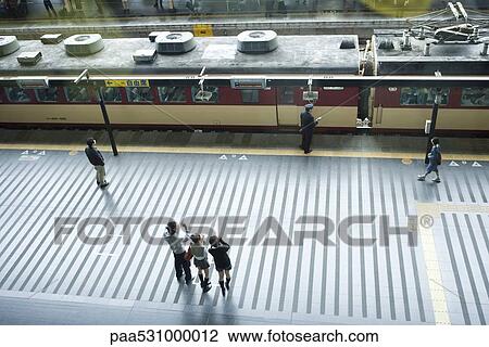 People standing on train platform, waving, high angle view View Large Photo Image Stock Image - People standing on train platform, waving, high angle view. Fotosearch