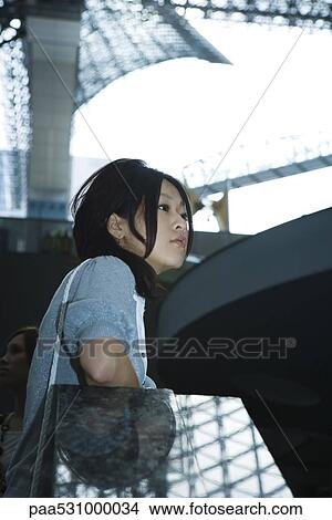 Young female leaning against railing, side view View Large Photo Image Picture - Young female leaning against railing, side view. Fotosearch