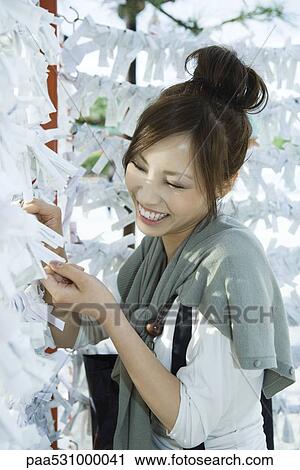 Young female reading traditional Japanese omikuji fortunes at Shinto shrine View Large Photo Image Stock Image - Young female reading traditional Japanese omikuji fortunes at Shinto shrine. Fotosearch