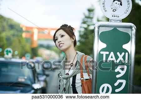 Young female waiting at taxi stand View Large Photo Image Stock Photograph - Young female waiting at taxi stand. Fotosearch