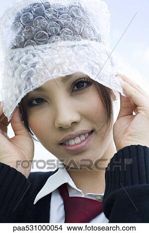 Picture - Young female wearing hat made of bubble wrap, portrait. Fotosearch