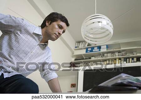 Man climbing onto desk, low angle view View Large Photo Image Stock Image - Man climbing onto desk, low angle view. Fotosearch