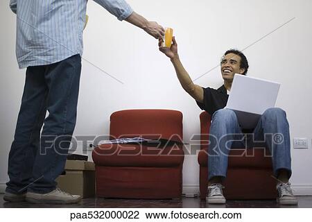 Stock Image - Man handing coffee cup to colleague. Fotosearch