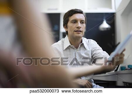 Man receiving document from colleague View Large Photo Image Stock Image - Man receiving document from colleague. Fotosearch