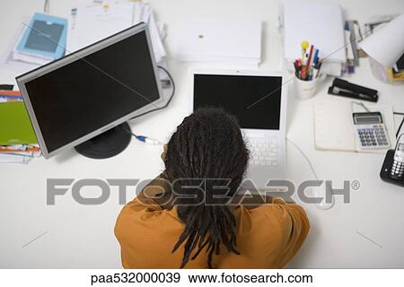 Man with dreadlocks working at desk, rear overhead view View Large Photo Image Stock Photo - Man with dreadlocks working at desk, rear overhead view. Fotosearch
