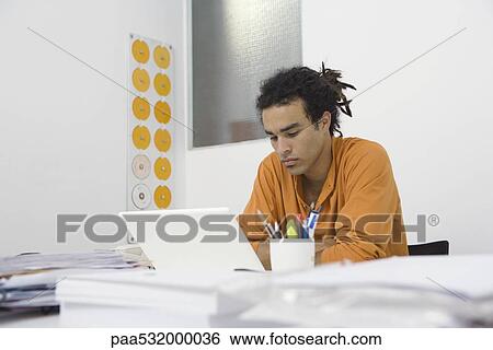 Man working at desk, arms folded View Large Photo Image Stock Photograph - Man working at desk, arms folded. Fotosearch