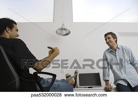 Men relaxing in casual office View Large Photo Image Stock Photo - Men relaxing in casual office. Fotosearch