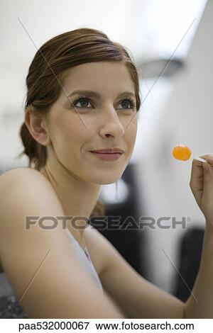 Young woman holding lollipop, looking away View Large Photo Image Stock Photo - Young woman holding lollipop, looking away. Fotosearch