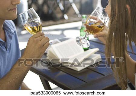 Couple drinking beer outdoors, open book on table in background View Large Photo Image Stock Photography - Couple drinking beer outdoors, open book on table in background. Fotosearch