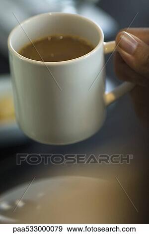Stock Photo - Hand picking up mug of coffee. Fotosearch