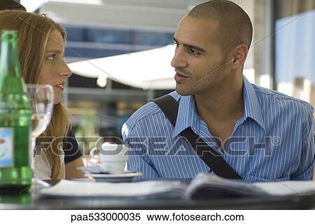 Man and woman sitting in outdoor cafe, having serious conversation View Large Photo Image Stock Photography - Man and woman sitting in outdoor cafe, having serious conversation. Fotosearch