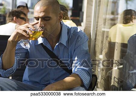 Man drinking a beer at a sidewalk cafe View Large Photo Image Stock Photo - Man drinking a beer at a sidewalk cafe. Fotosearch