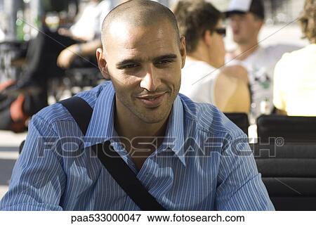 Man sitting outdoors, smiling View Large Photo Image Stock Photo - Man sitting outdoors, smiling. Fotosearch