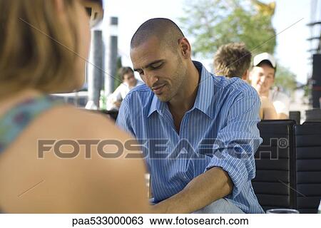 People sitting at sidewalk cafe, focus on man in middle ground View Large Photo Image Stock Image - People sitting at sidewalk cafe, focus on man in middle ground. Fotosearch