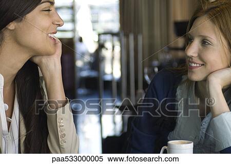 Two female friends having coffee and chatting in cafe View Large Photo Image Stock Photography - Two female friends having coffee and chatting in cafe. Fotosearch