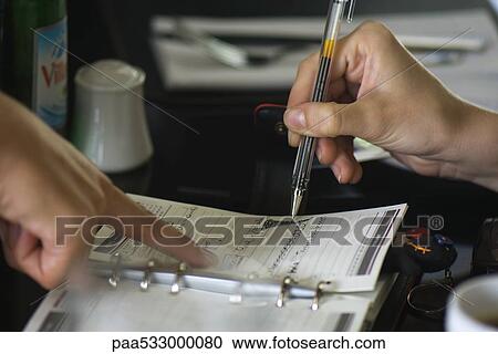 Two people making plans using agenda, one holding pen while the other points to page View Large Photo Image Stock Image - Two people making plans using agenda, one holding pen while the other points to page. Fotosearch