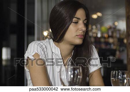 Woman sitting in restaurant, looking away View Large Photo Image Stock Image - Woman sitting in restaurant, looking away. Fotosearch