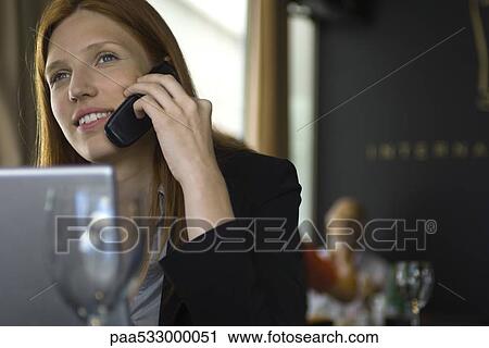Woman using cell phone in restaurant View Large Photo Image Stock Image - Woman using cell phone in restaurant. Fotosearch