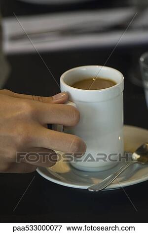 Woman's hand picking up cup of coffee, close-up View Large Photo Image Stock Photo - Woman's hand picking up cup of coffee, close-up. Fotosearch