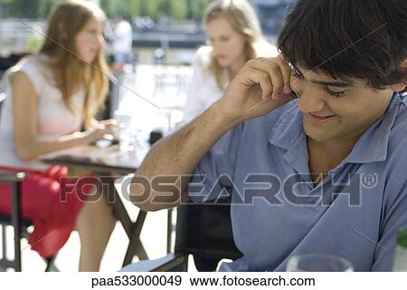 Stock Photo - Young man using cell phone outdoors. Fotosearch
