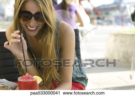 Young woman drinking cool beverage outdoors View Large Photo Image Stock Image - Young woman drinking cool beverage outdoors. Fotosearch