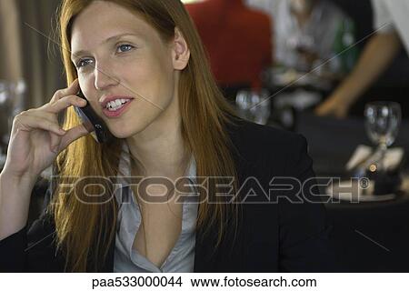 Young woman in restaurant using cell phone View Large Photo Image Picture - Young woman in restaurant using cell phone. Fotosearch