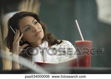 Woman sitting in cafe with notebook, holding head View Large Photo Image Stock Photograph - Woman sitting in cafe with notebook, holding head. Fotosearch