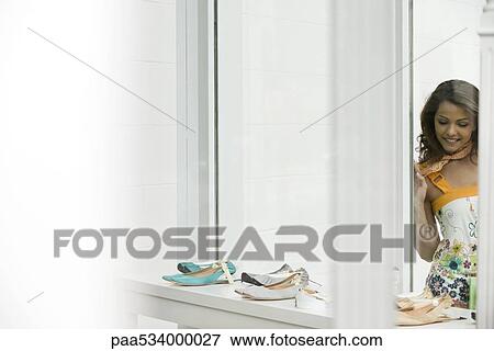 Young woman looking at shoes in shop window View Large Photo Image Stock Photo - Young woman looking at shoes in shop window. Fotosearch