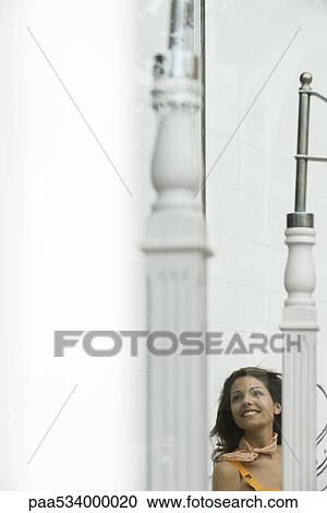 Young woman looking through window, smiling View Large Photo Image Stock Image - Young woman looking through window, smiling. Fotosearch