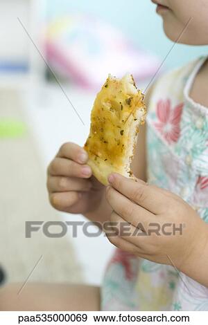 Stock Photo - Child eating slice of pizza, cropped view. Fotosearch