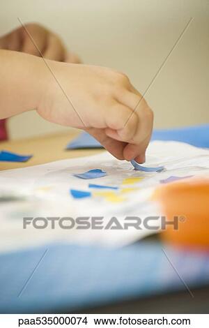 Child making collage with glue and paper, cropped view of hands View Large Photo Image Picture - Child making collage with glue and paper, cropped view of hands. Fotosearch