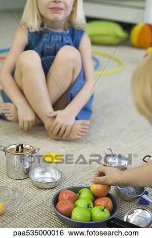 Children sitting on floor, playing with pots and pans, cropped View Large Photo Image Stock Photograph - Children sitting on floor, playing with pots and pans, cropped. Fotosearch