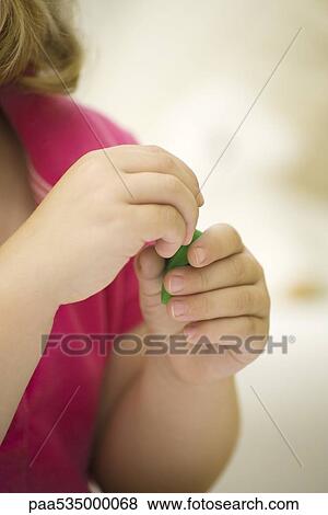 Stock Photo - Child's hands holding green clay. Fotosearch