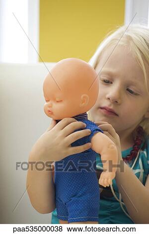 Little girl dressing baby doll View Large Photo Image Stock Photo - Little girl dressing baby doll. Fotosearch