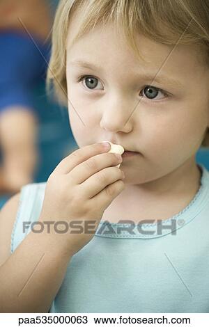 Little girl eating marshmallow View Large Photo Image Stock Image - Little girl eating marshmallow. Fotosearch