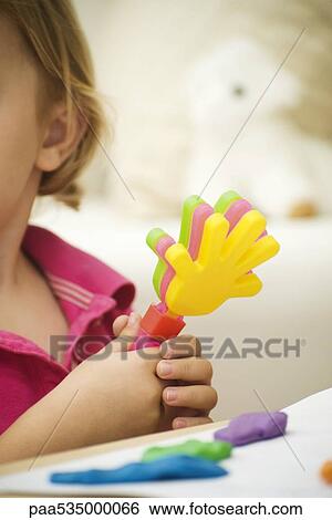 Little girl holding plastic clapping toy, cropped view View Large Photo Image Stock Photograph - Little girl holding plastic clapping toy, cropped view. Fotosearch