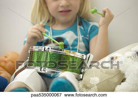 Stock Photo - Little girl playing drum, cropped view. Fotosearch