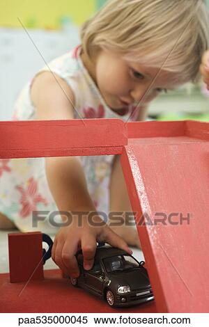 Stock Photography - Little girl playing with toy car. Fotosearch