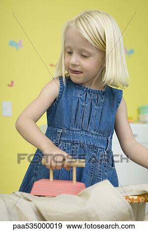 Little girl playing with toy iron and ironing board View Large Photo Image Stock Photo - Little girl playing with toy iron and ironing board. Fotosearch